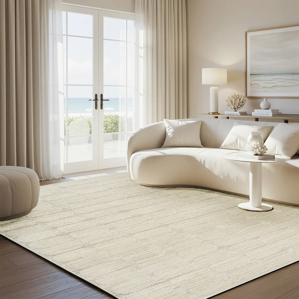 Cream geometric rug in elegant coastal living room with curved sofa and French doors